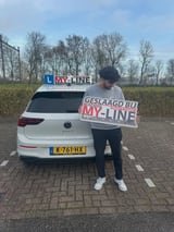 Geslaagde leerling met het bord van MY-Line bij de lesauto of lesmotor